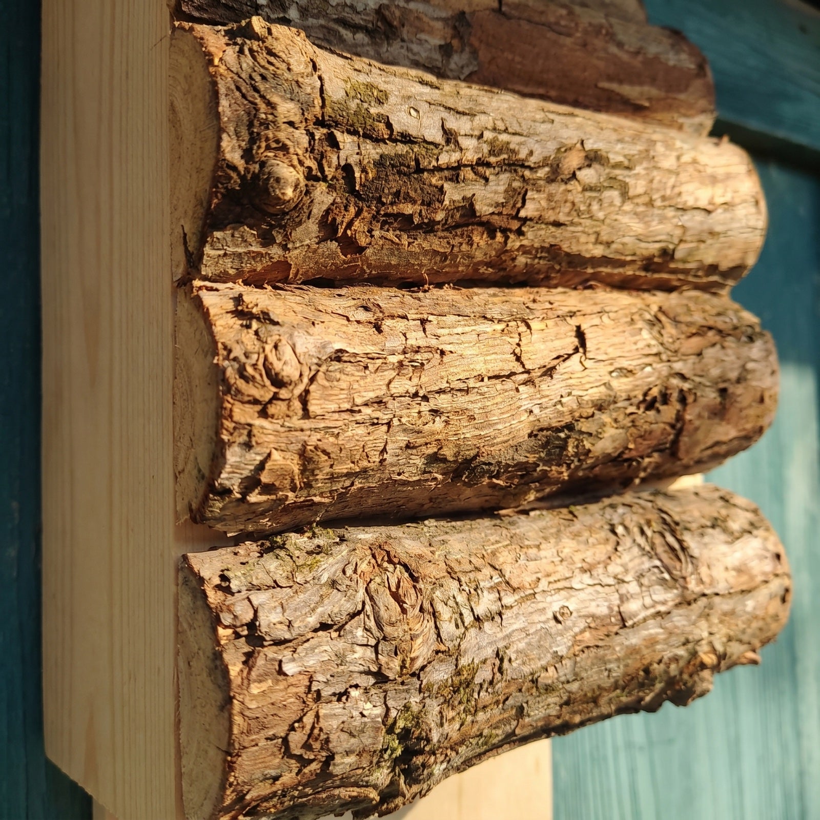 Macro detail of the thick untreated bark-on logs and the narrow gaps between them